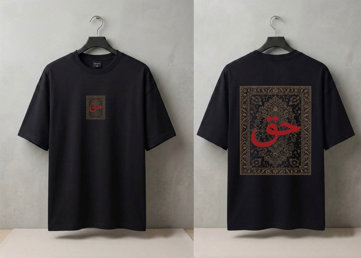 A black short-sleeve T-shirt shown from both front and back on hangers against a light gray wall. The front has a small square chest graphic with red calligraphy, and the back has a large rectangular graphic with ornate detailing and a prominent red calligraphy motif.