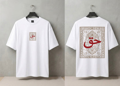 A white short-sleeve T-shirt shown from both front and back, hanging on a black hanger against a light gray wall. The front has a small square beige graphic with red Arabic calligraphy on the left chest.